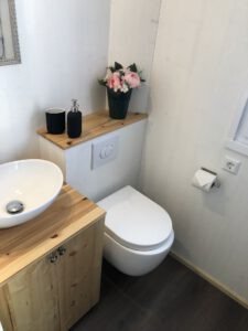 Blick ins Bad mit WC, Waschbecken und Unterschrank